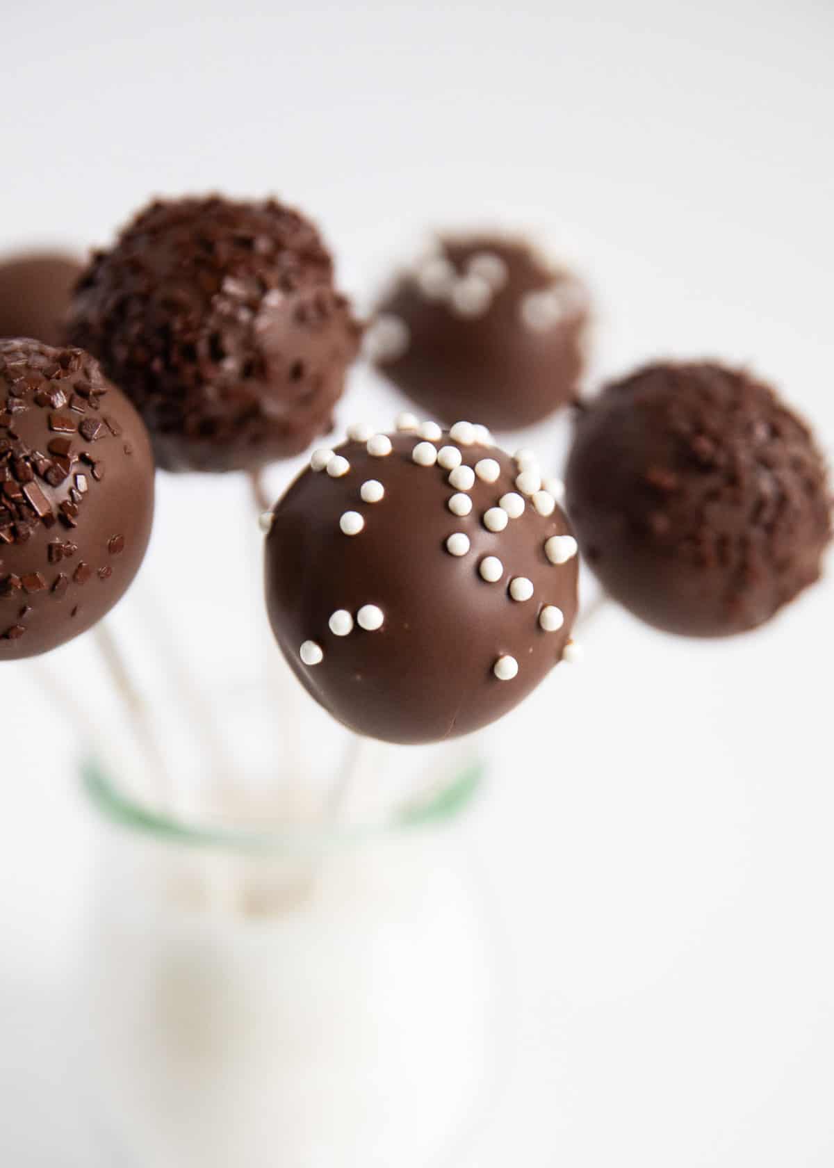 Chocolate cake pops are taken up a notch with this recipe using 3 times the chocolate! These portable bite-sized treats are rich, decadent and so much fun to eat! Chocolate cake pops in jar.