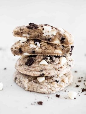 Stacked cookies and cream cookies with the top broke in half to show thick, chewy texture.