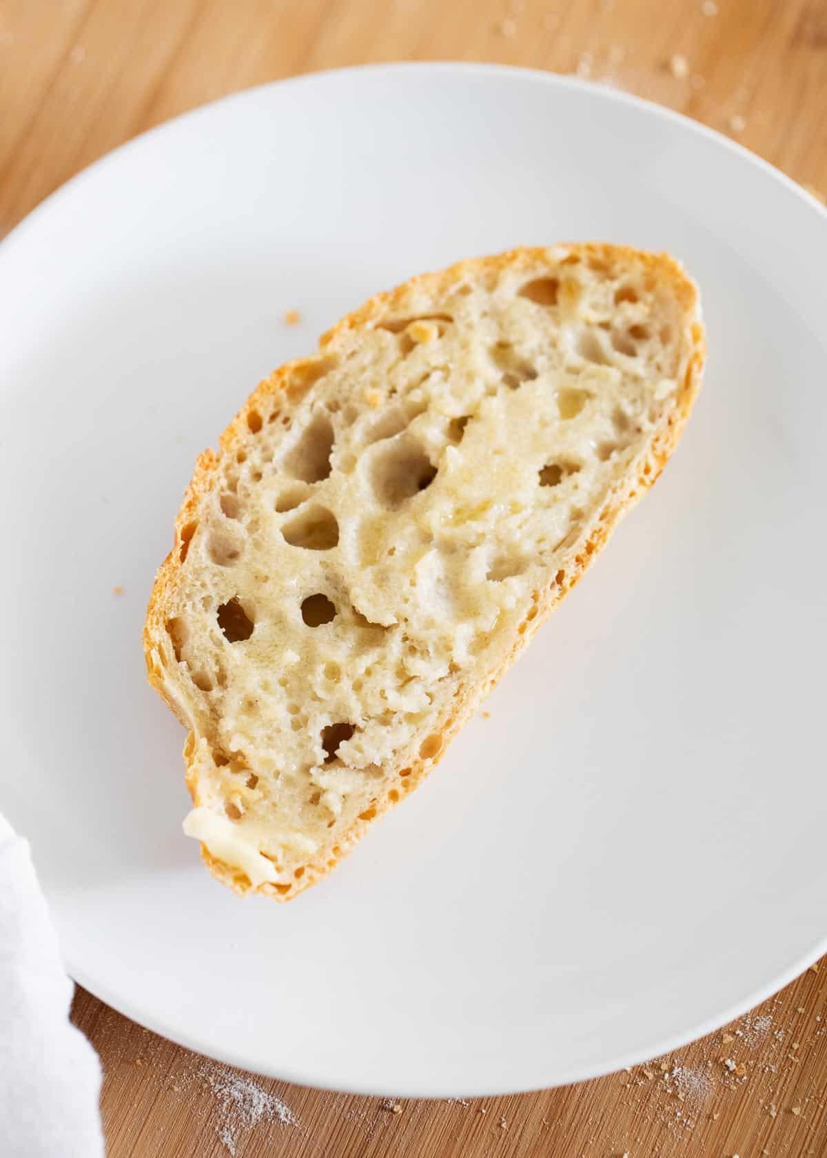 Piece of dutch oven bread on white plate.