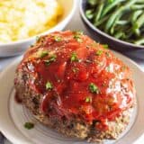 meatloaf on plate with mashed potatoes and green beans