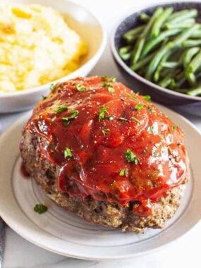 meatloaf on plate with mashed potatoes and green beans