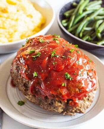 meatloaf on plate with mashed potatoes and green beans