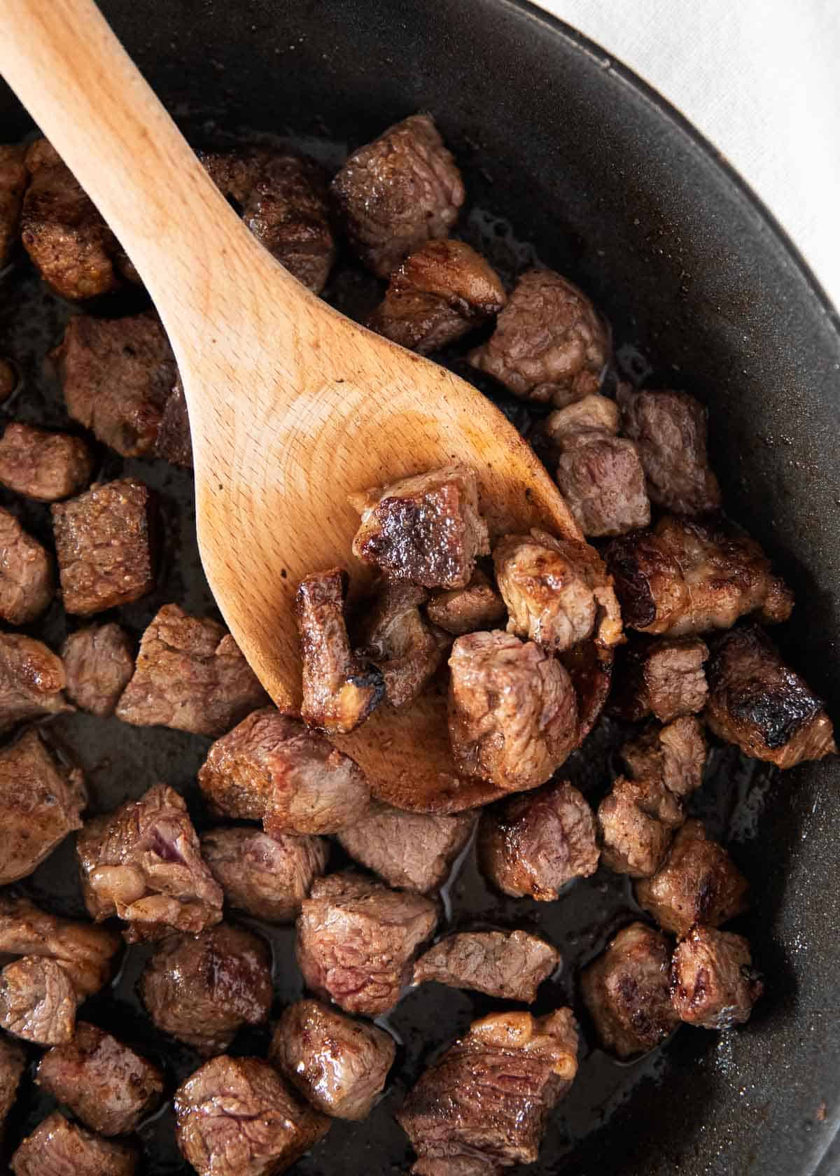 Steak bites in pan.