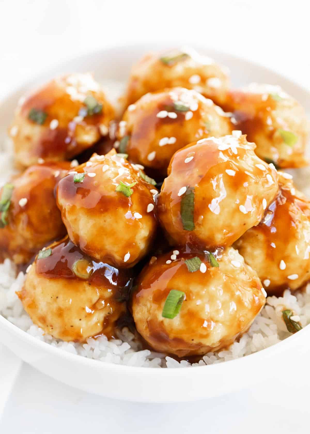 Teriyaki meatballs in a bowl with white rice.