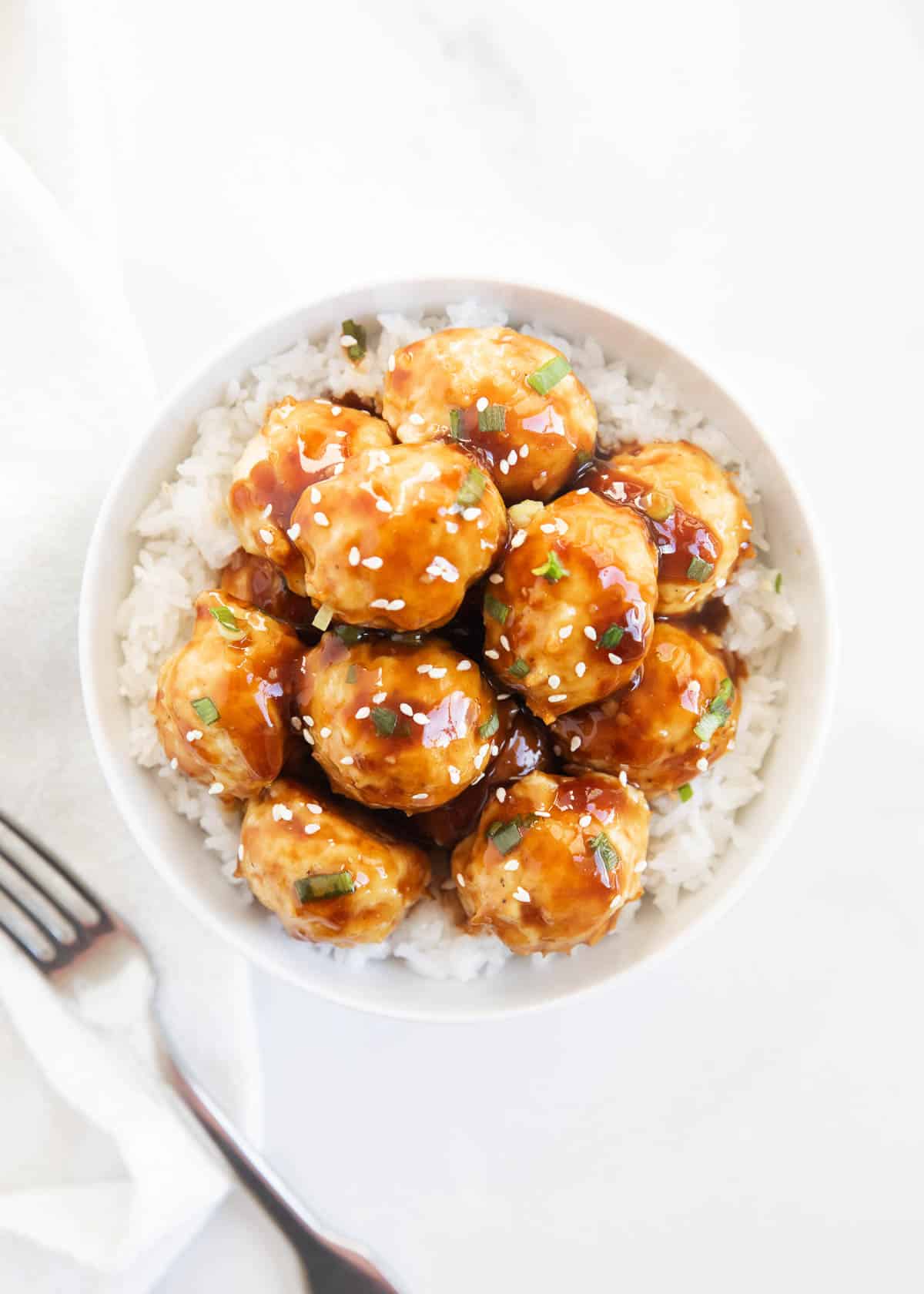 Teriyaki meatballs in bowl with rice.