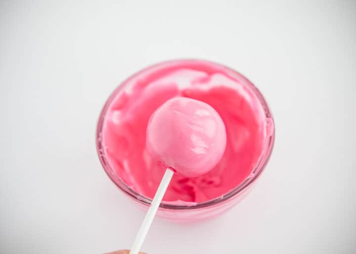 dipping cake pop in pink melted chocolate 