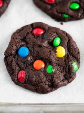 Chocolate m&m cookie on a baking sheet.