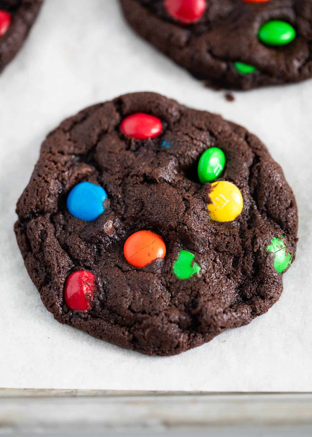 Chocolate m&m cookie on a baking sheet.