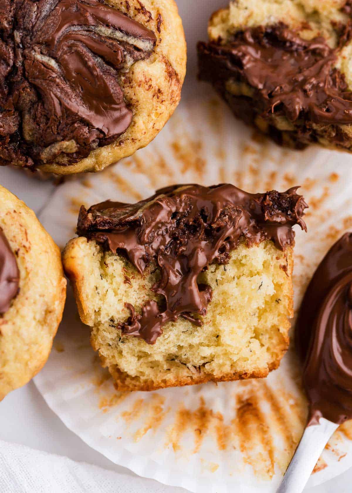 A banana Nutella muffin unwrapped from liner and broke in half.