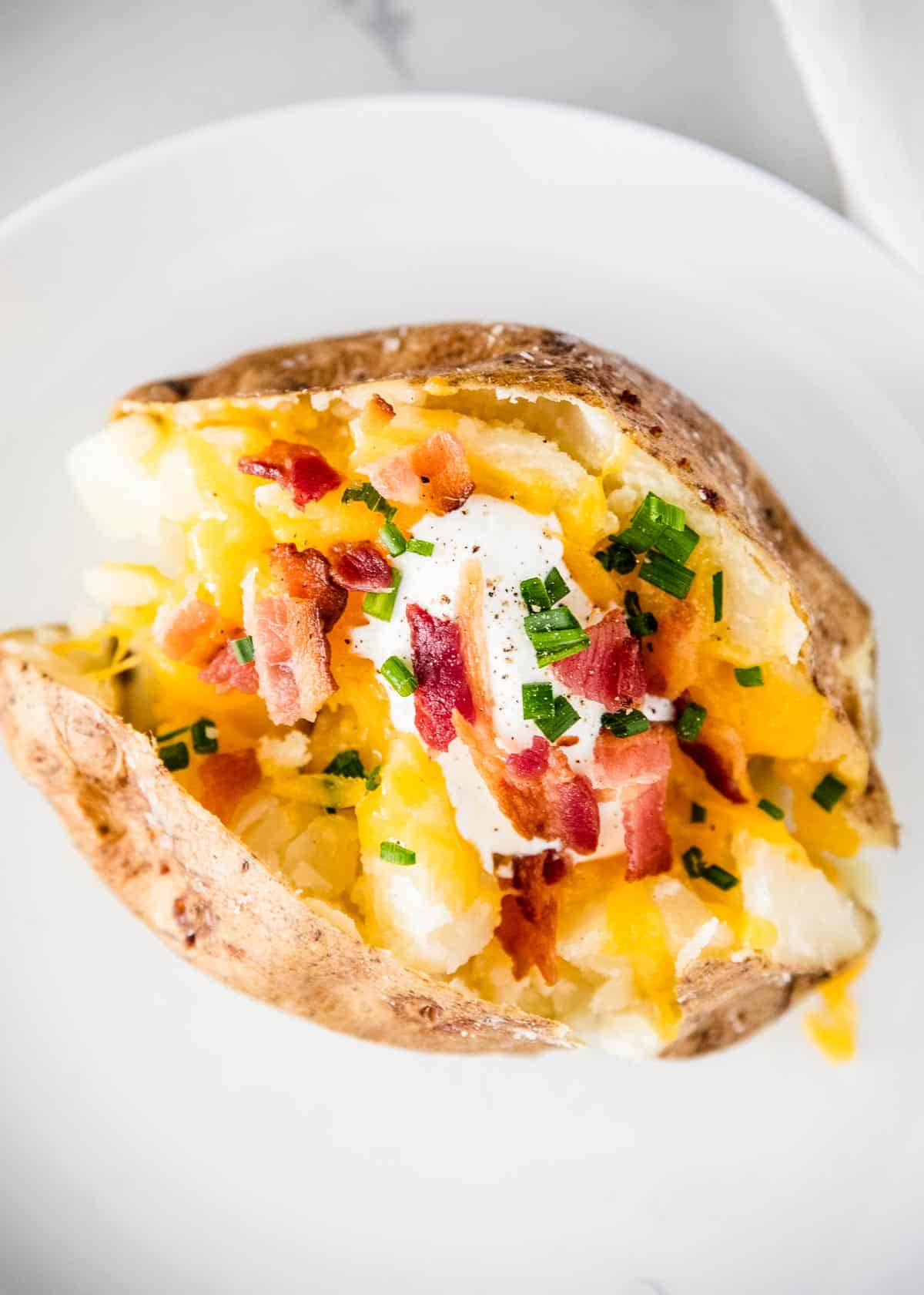 Loaded baked potato on plate.