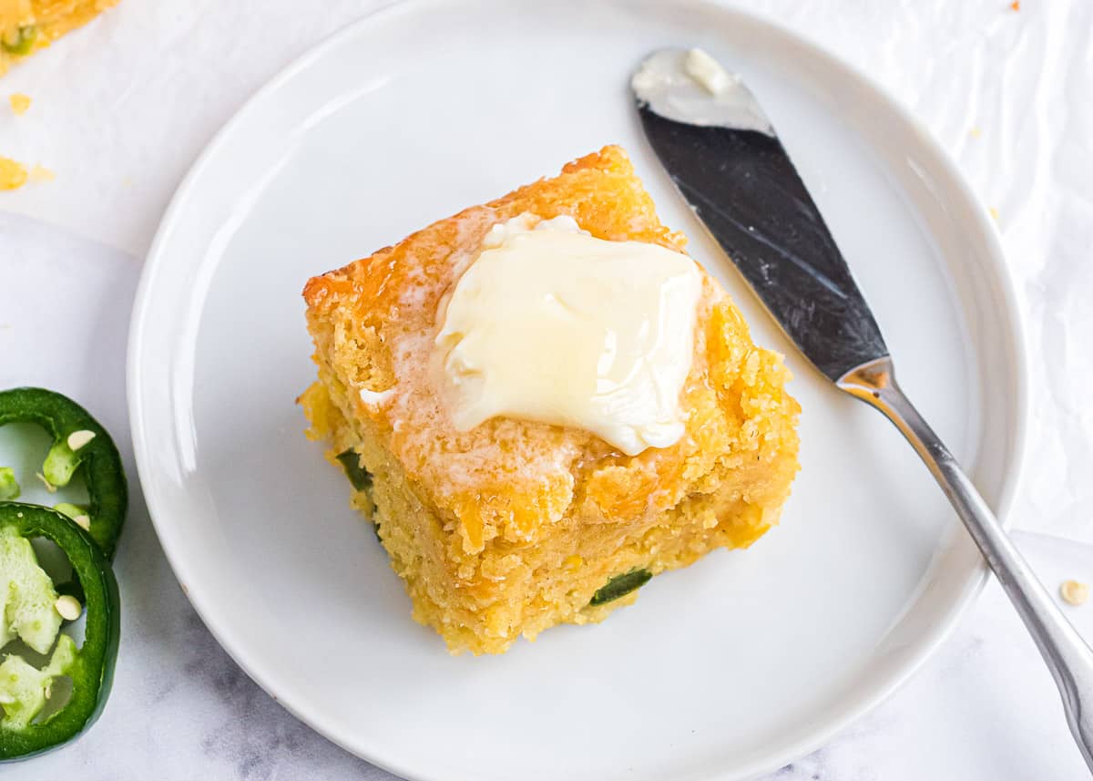 Slice of cornbread on white plate.