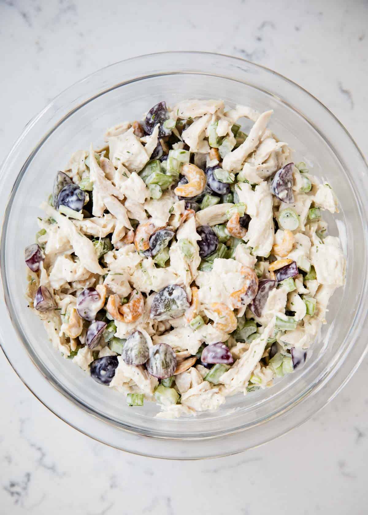 Chicken salad mixed in a glass bowl.