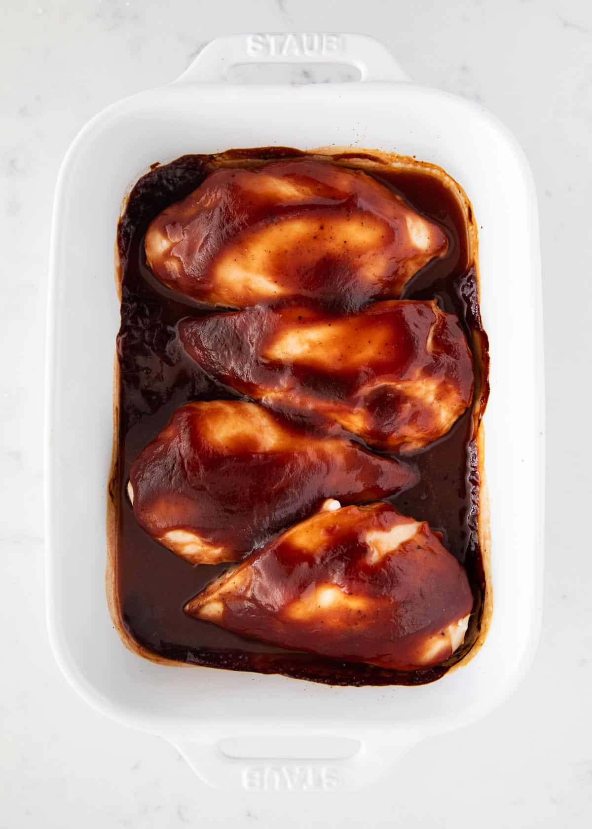 Baked bbq chicken in white platter.