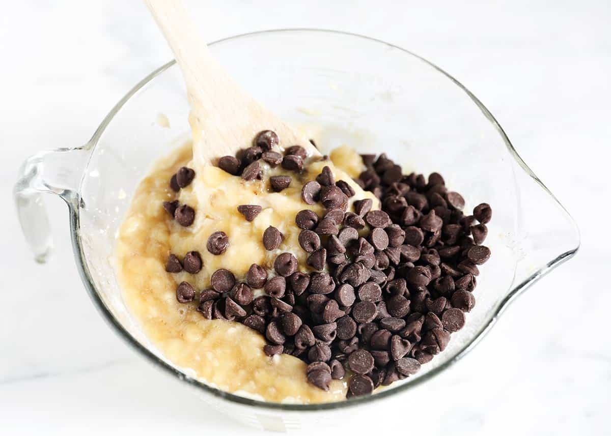 Banana bread batter in bowl with chocolate chips.