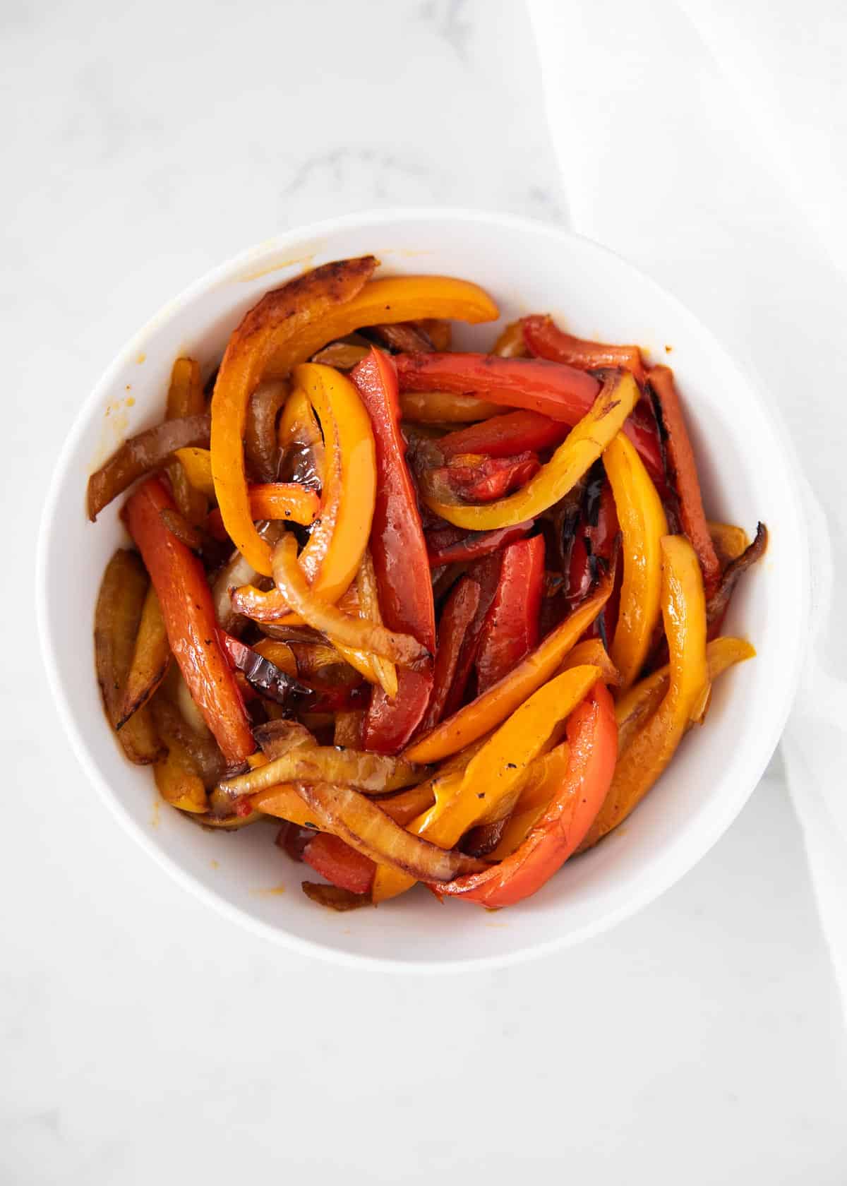 Fajita veggies in white bowl.