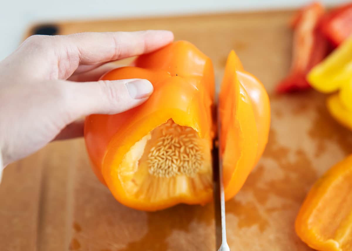 Bell peppers being cut on cutting board.