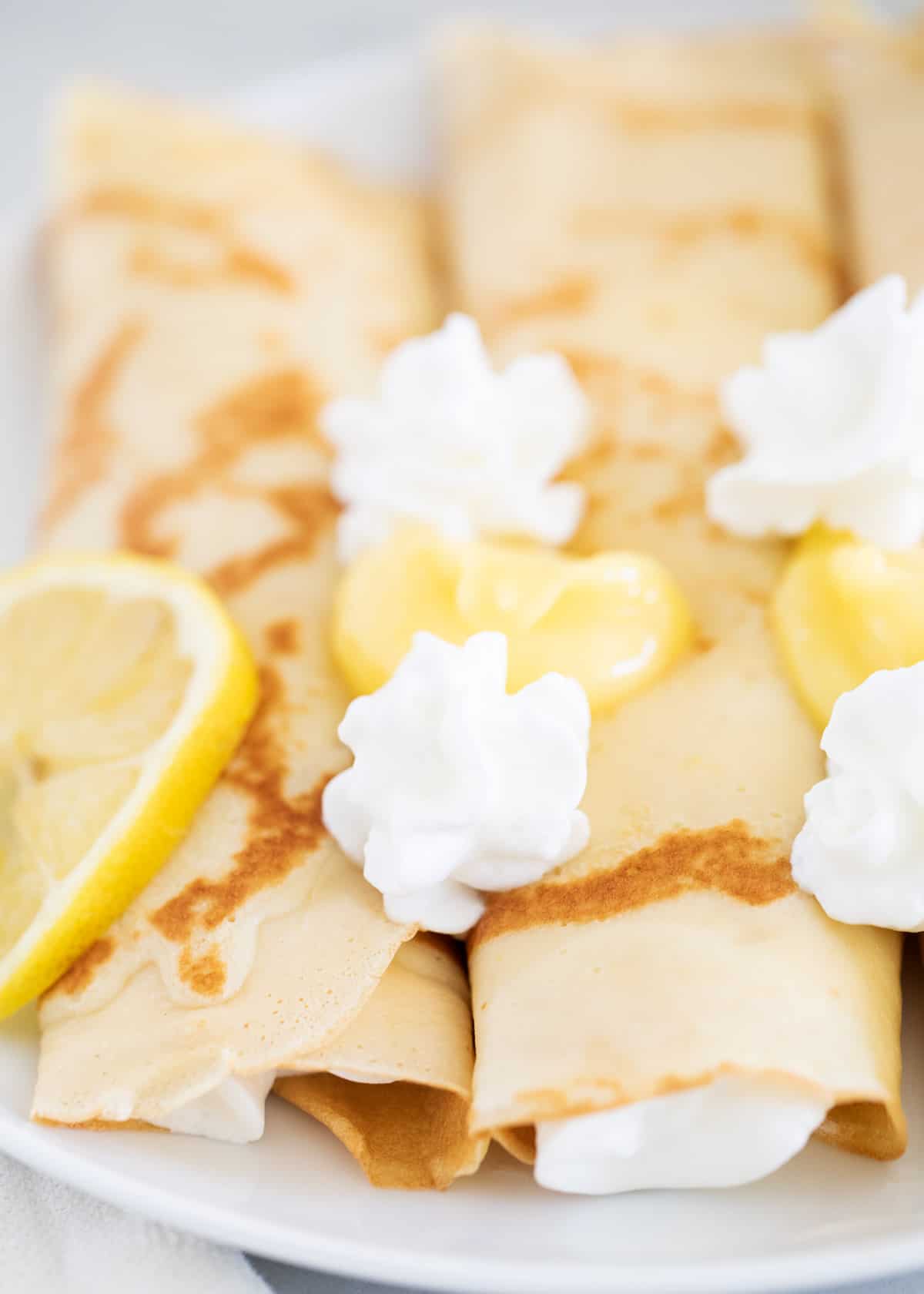 Lemon crepes on white plate close up.