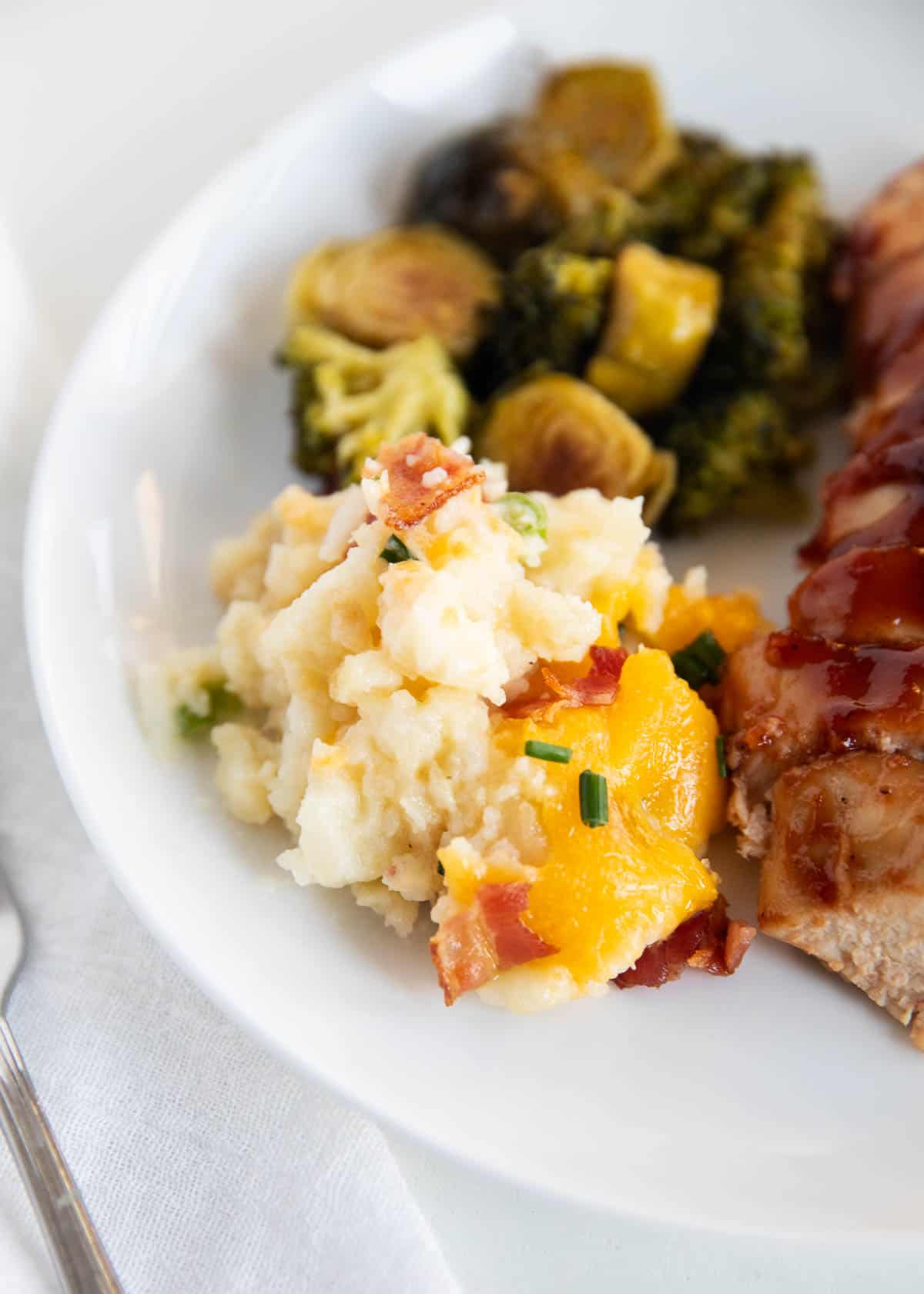 Loaded baked potato casserole on white plate.