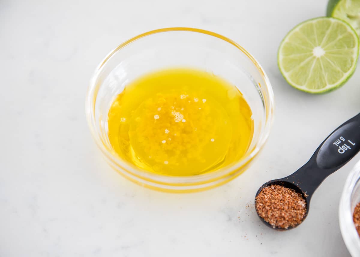 Oil in a bowl with seasonings on table.