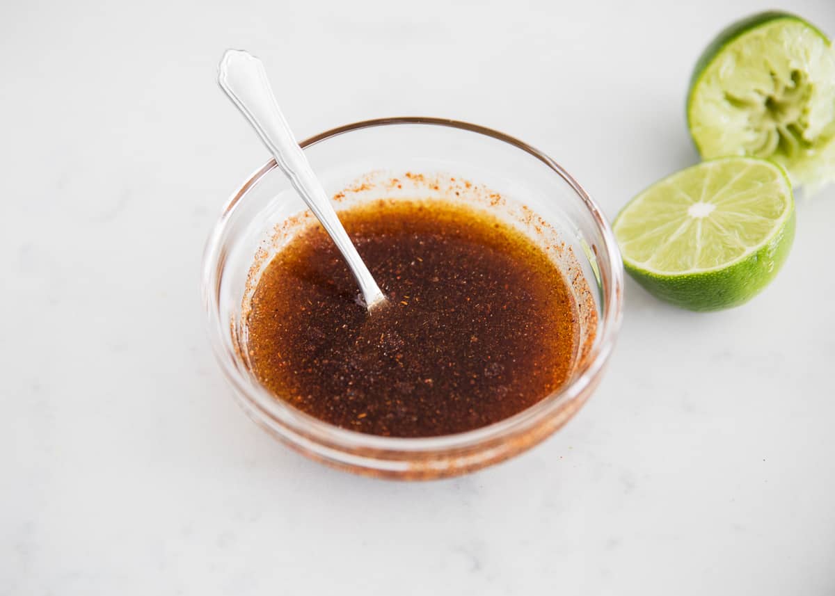 steak fajita marinade in bowl with limes