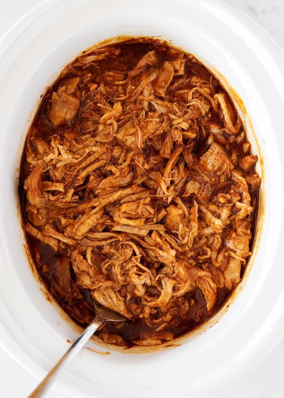 BBQ pulled pork in the white slow cooker.