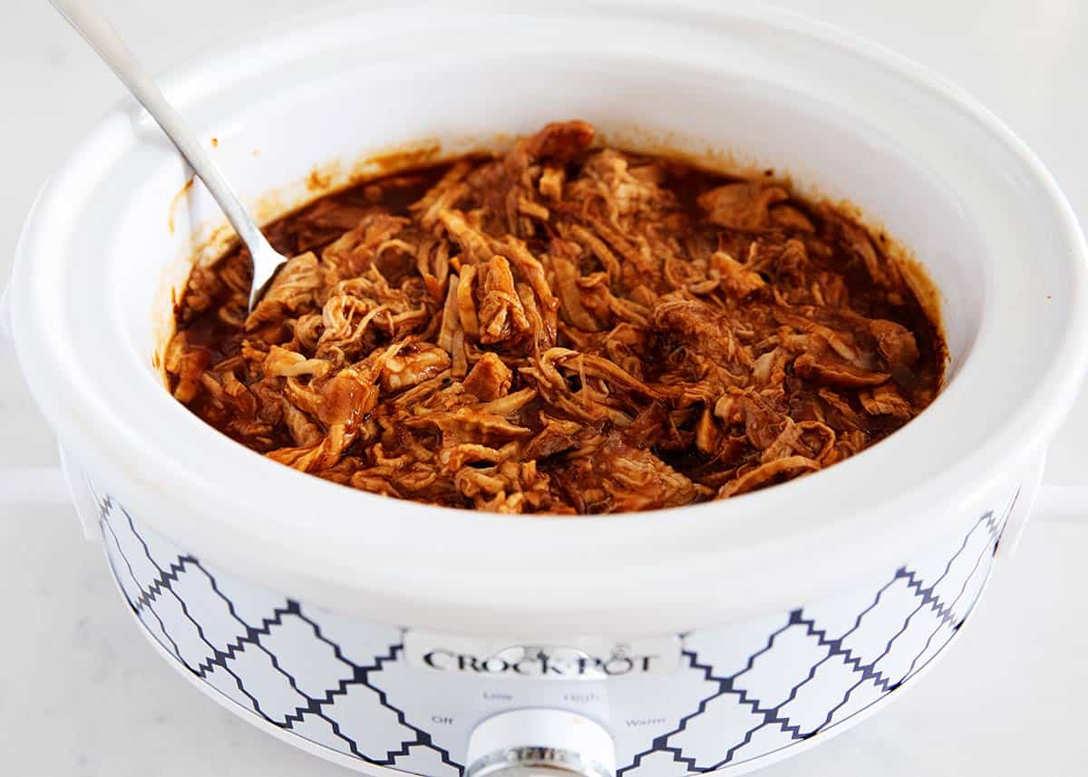 BBQ pulled pork in white crock pot.