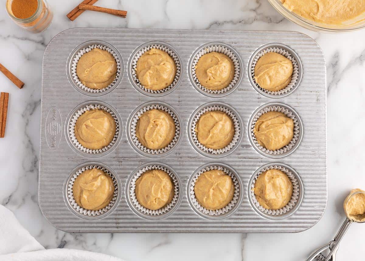 Churro cupcake batter tins in pan.