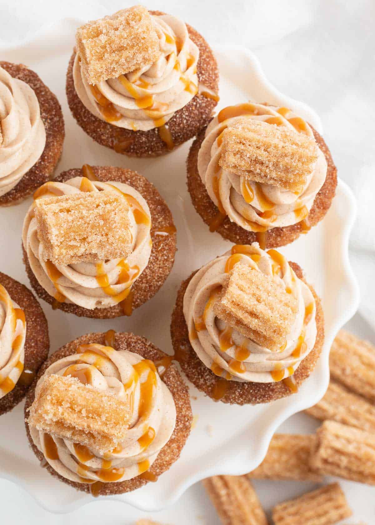 Churro cupcakes on white platter.