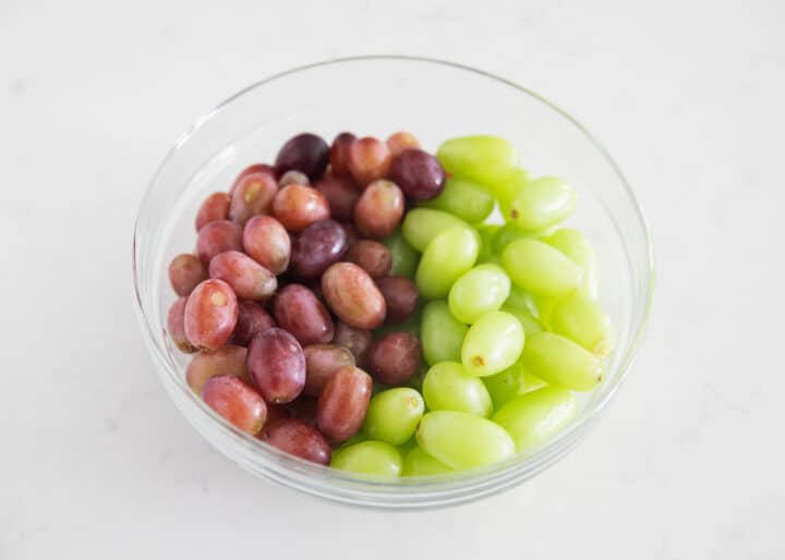 red and green grapes in clear bowl