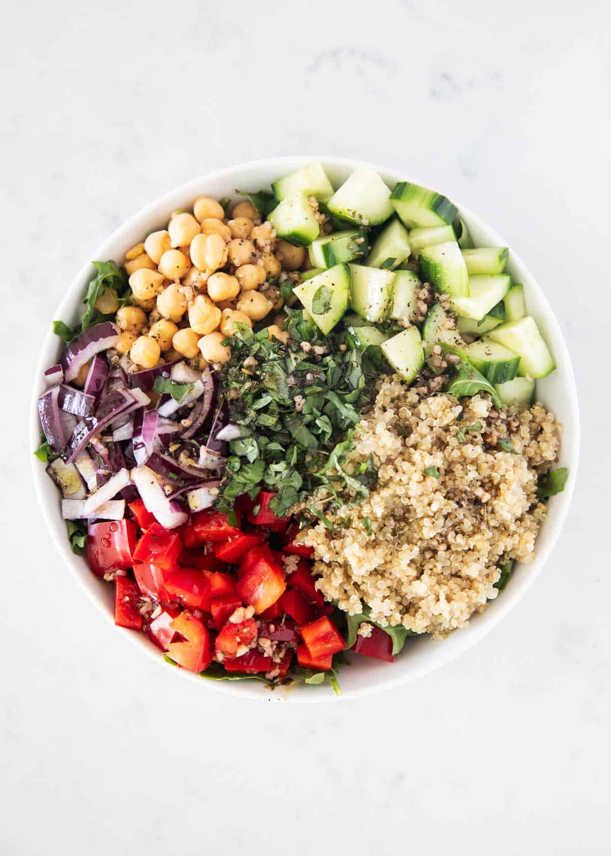 Quinoa mediterranean salad ingredients in bowl.