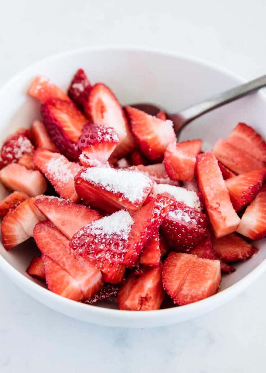 strawberries and sugar in white bowl