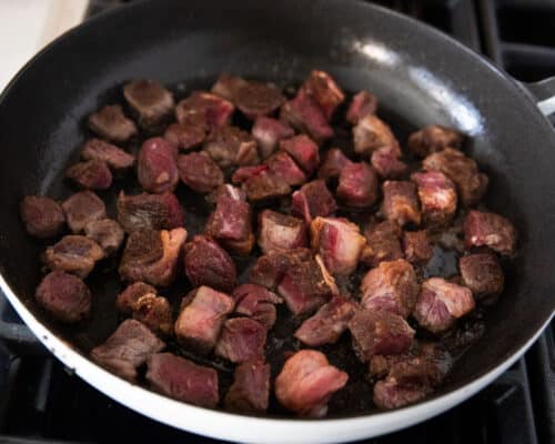 steak bites cooking in pan