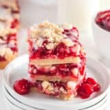 cherry pie bars stacked on white plates