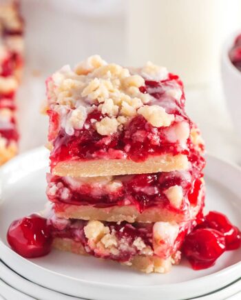 cherry pie bars stacked on white plates