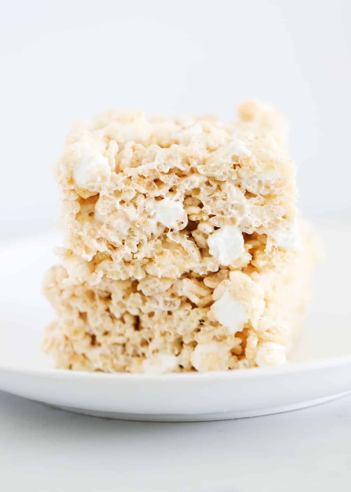 Brown butter rice krispie treats on white plate.