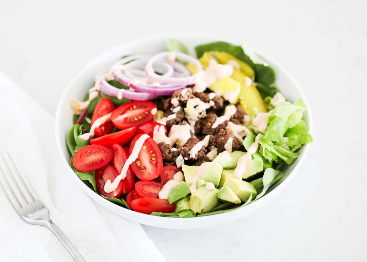 Burger salad in white bowl.