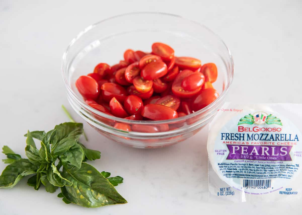 Caprese pasta salad ingredients on table.