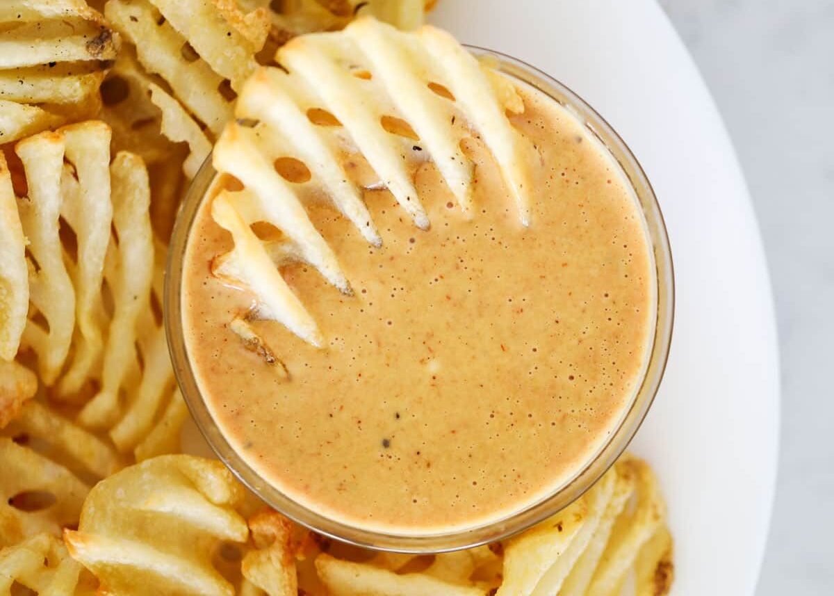 This copycat version of the popular Chick-fil-A sauce recipe is one that goes with everything! Made with a quick blend of just 5 simple ingredients, it's so good you'll be licking it off the spoon! Waffle fry dipped in sauce.