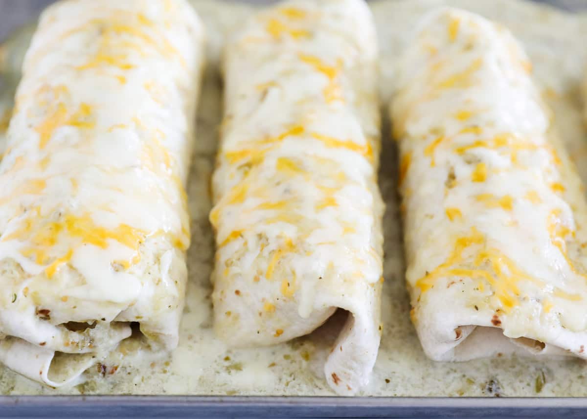 Cooked chicken burritos on pan.