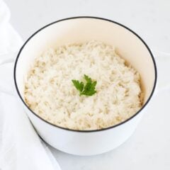 Coconut rice in a white pot with cilantro garnish.