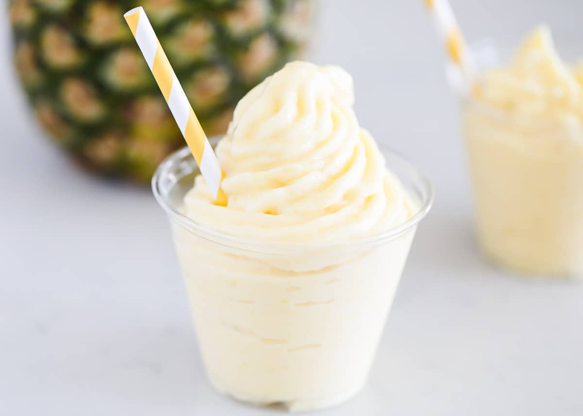 Creamy and sweet pineapple Dole Whip that's made with 3 simple ingredients in just 5 minutes. This Disney copycat recipe is bursting with tropical flavor and is the perfect refreshing treat to cool off with on a hot summer day. Dole whip in plastic cup.
