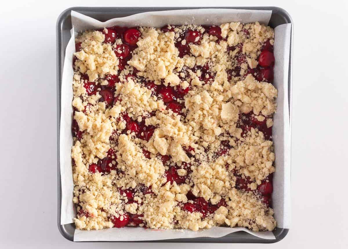 Cherry pie bars with crumble topping in pan.