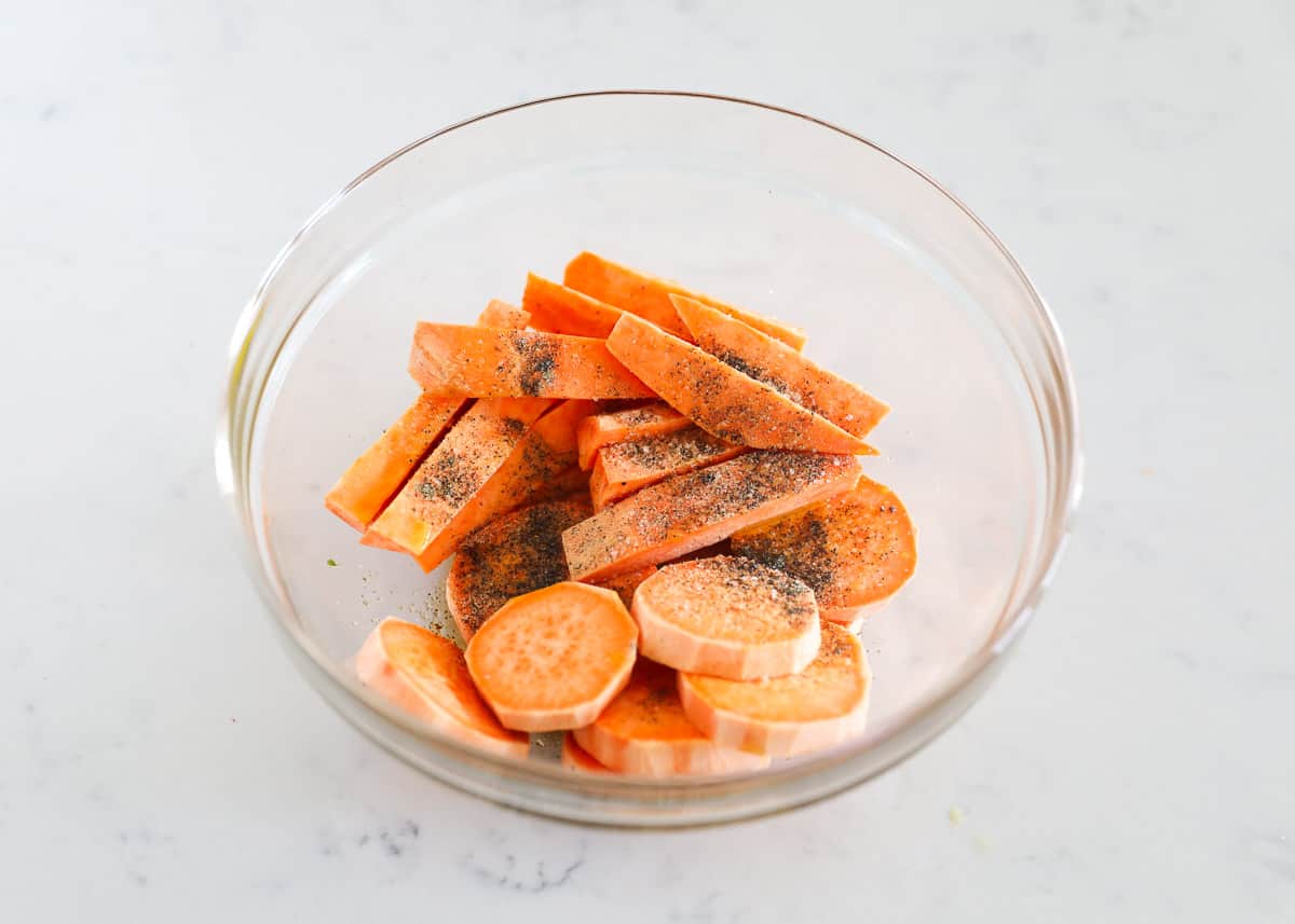 Cut sweet potato and seasonings in bowl.