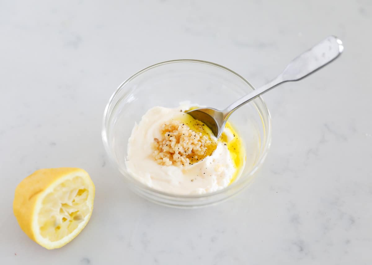 Garlic aioli ingredients in small glass bowl.