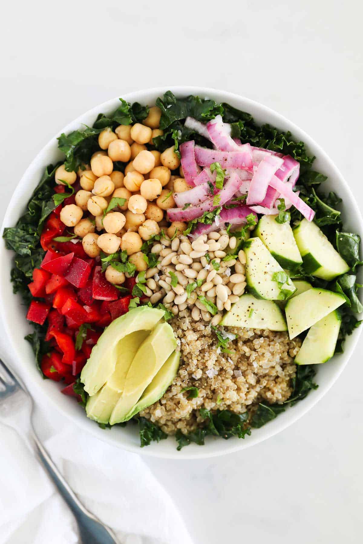 Kale quinoa salad in white bowl.