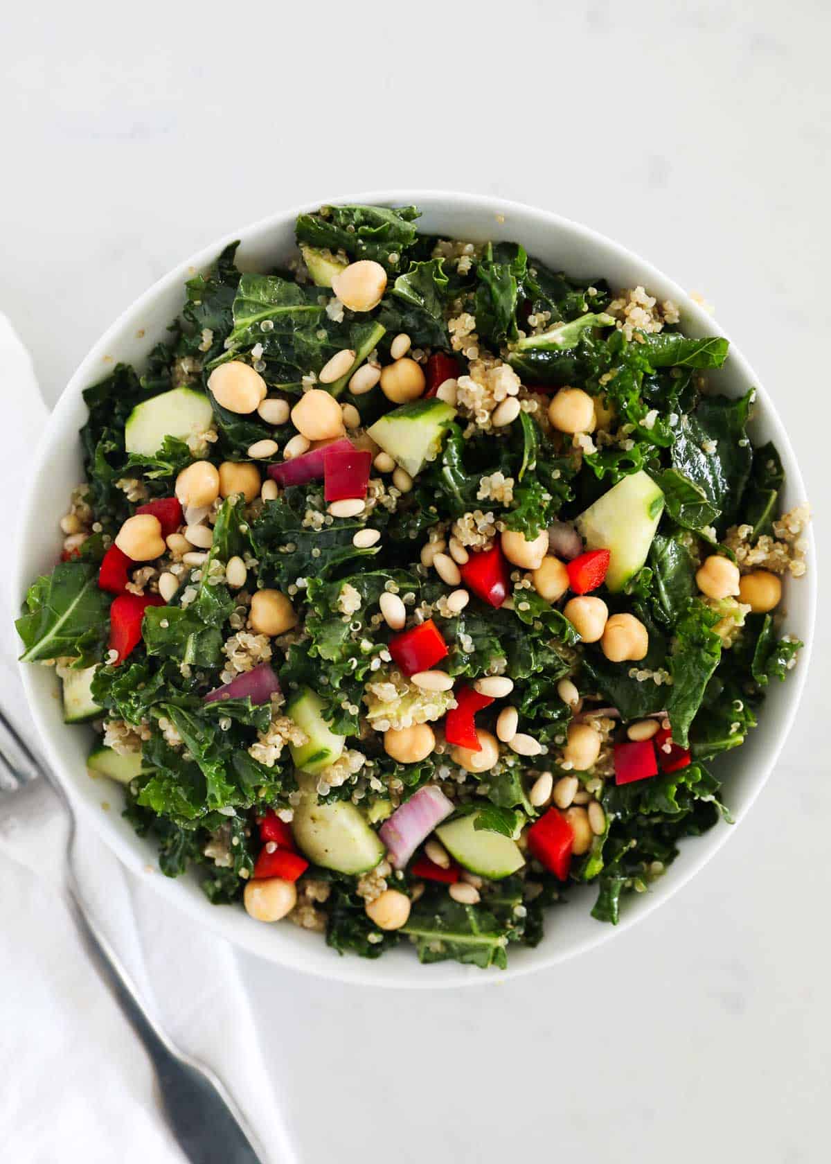 Kale quinoa salad in white bowl.