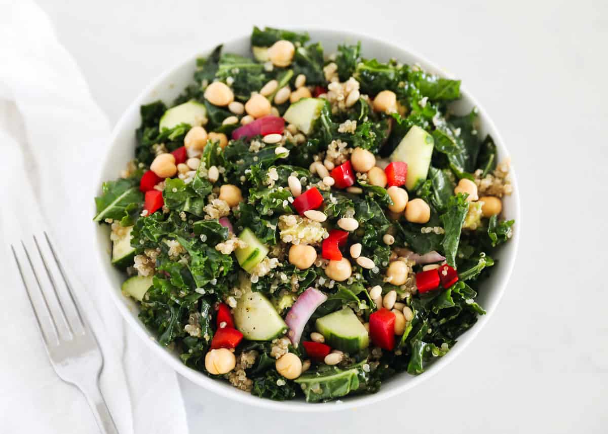 Kale quinoa salad in white bowl.