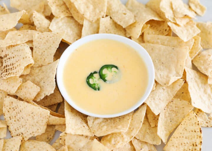 nacho cheese dip and chips on table