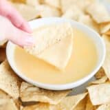 nacho cheese dip and chips on table