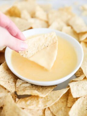 nacho cheese dip and chips on table